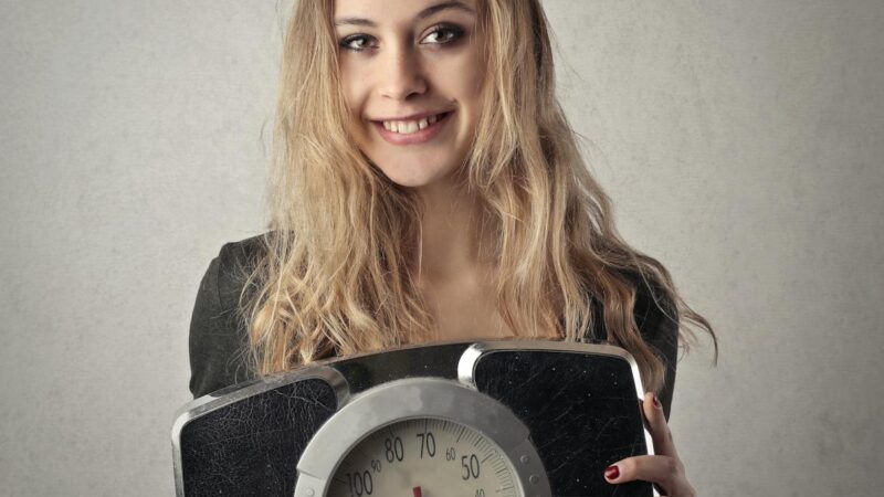 woman in black shirt holding black and silver weight scale